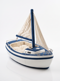 Sailboat-shaped plush dog bed with mast and sail detail